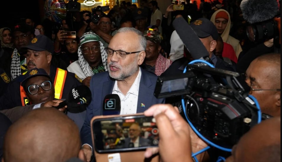 سفير جنوب إفريقيا السابق لدى الولايات المتحدة إبراهيم رسول (وسط) لدى وصوله إلى مطار كيب تاون في 23 مارس 2025