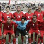 المنتخب الوطني المغربي النسوي لكرة القدم في صورة جماعية أرشيفية بالقمصان الحمراء على أرضية ملعب.