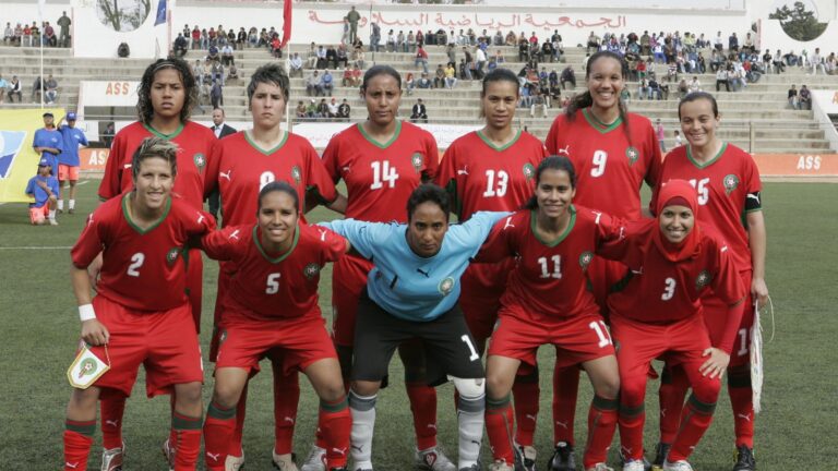 المنتخب الوطني المغربي النسوي لكرة القدم في صورة جماعية أرشيفية بالقمصان الحمراء على أرضية ملعب.